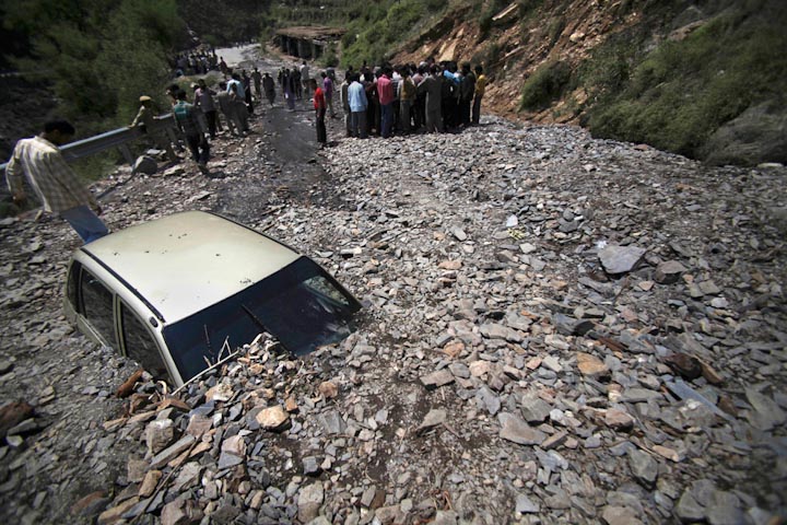 Автомобиль лежит среди оползневых масс после сильного дождя в Доде, Индия, 9 июня. Оползень унес жизни не менее четырех человек.