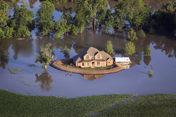 Насыпь защищает дом, окруженный водами реки Язу, близ Виксберга, штат Миссисипи, 18 мая. После разлива Миссисипи, река Язу также вышла из берегов. От наводнения пострадали территории, расположенные вдоль берегов Миссисипи от Иллинойса до Луизианы.