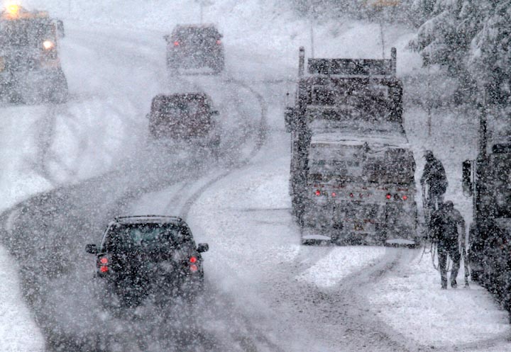 Водители грузовиков остановились на дороге во время снегопада в городе Говермент Кэмп, штат Орегон, 6 апреля. Зимняя погода, несвойственная этому времени года, принесла низкие температуры и метели во многие регионы штата. 