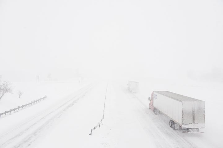 Грузовики исчезают в пелене снега на шоссе I-70 близ Бунвилля, штат Миссури. Сильнейшая за последние десятилетия снежная буря в Миссури принесла 30 см снега, ледяной дождь, ветры и низкие температуры. 
