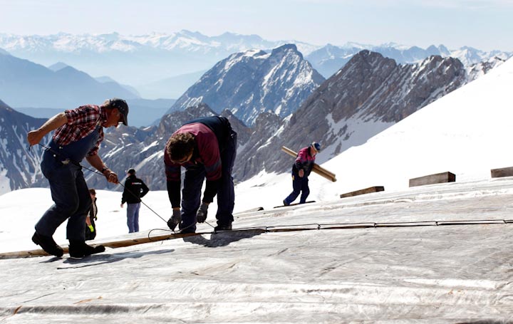 Рабочие укрывают тентами лед на склонах горы Цугшпитце, самой высокой вершины Германии, 10 мая. Чтобы сохранить горнолыжный курорт к следующему зимнему сезону, лед защищают от таяния с мая по сентябрь.
