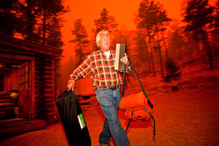 Джим Пинтер покидает свой дом во время лесного пожара «Уоллоу» в Алпайне, штат Аризона, 2 июня. Сильные ветры и высокие температуры препятствовали работе пожарных, которые пытались локализовать лесной огонь.